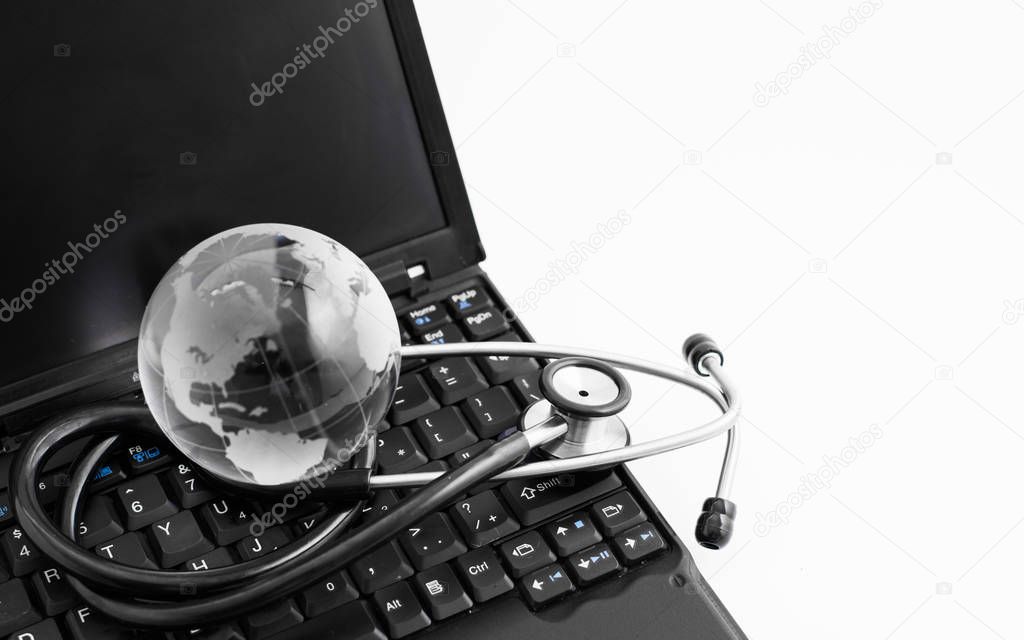 Glass globe and stethoscope on a computer keyboard.