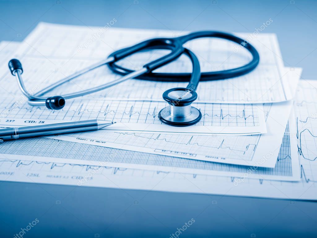 Stethoscope on cardiogram concept for heart care on the desk.