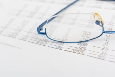 Masadaki mali tabloda gözlük var..