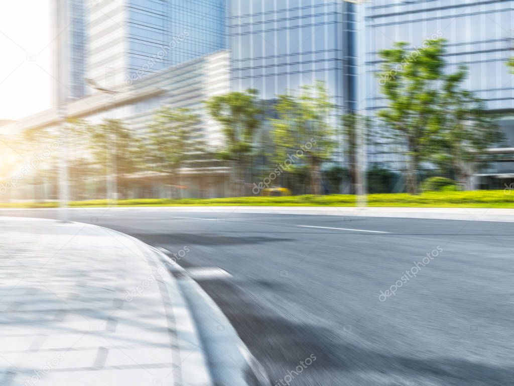 empty asphalt road by modern office building.