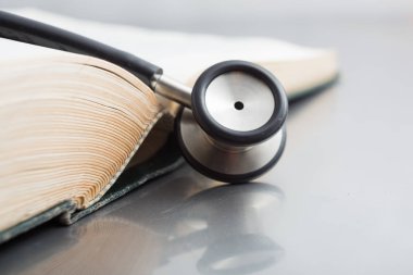 Steteskop ve beyaz zemin üzerine kitaplar.