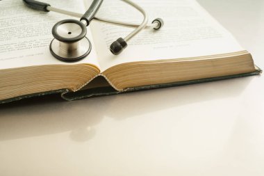Steteskop ve beyaz zemin üzerine kitaplar.