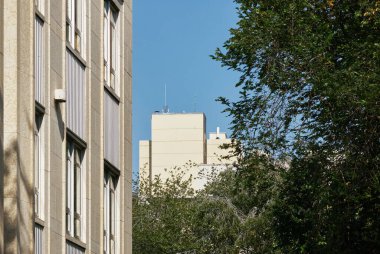 Kanada Saskatoon 'da çekilmiş, yakınlardaki mimariyi yansıtan büyük cam pencereli modern tuğla ofis binasının yan açısı.