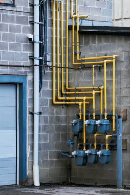 Sarı gaz borularının ve Saskatoon, Kanada 'da beton bir duvarın üzerindeki metrelerin yakın görüntüsü..