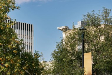 Kanada Saskatoon 'da çekilmiş, yakınlardaki mimariyi yansıtan büyük cam pencereli modern tuğla ofis binasının yan açısı.