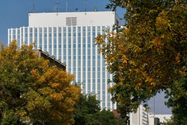Kanada Saskatoon 'da çekilmiş, yakınlardaki mimariyi yansıtan büyük cam pencereli modern tuğla ofis binasının yan açısı.
