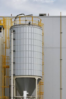 Kanadanın Saskatoon şehrinde çekilen, sarı metal merdivenleri ve boruları olan sanayi tipi depolama silolarının yakın görüntüsü..