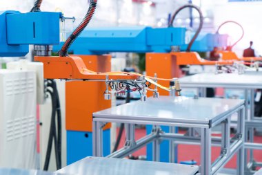 Vakumlu robotlar üretim fabrikasındaki konveyörden bir şey seçiyor.