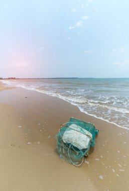 Kumsalda köpüklü eski yengeç kafesi