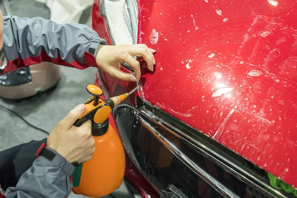塗装保護フィルムをインストールするために車に水を噴霧労働者 — ストック写真