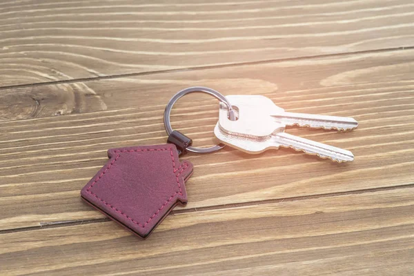 Schlüsselanhänger Mit Haussymbol Und Schlüsseln Auf Holzgrund Immobilienkonzept — Stockfoto