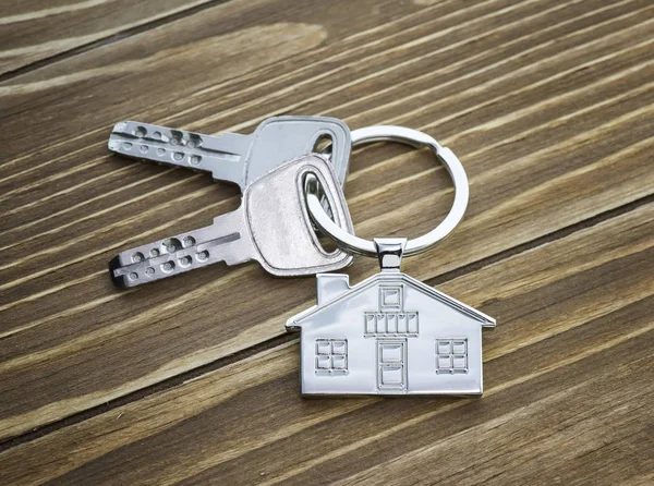 Přívěšek Klíče Symbolem Domu Klíči Dřevěném Pozadí Koncept Nemovitostí — Stock fotografie