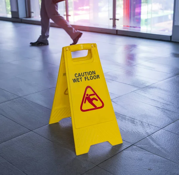 Yellow Caution wet floor sign on wet floor