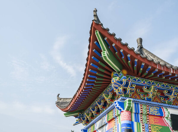 Chinese style temple roof against blue sky background