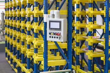 Otomatik deponun hücrelerindeki plastik kutular. Metal inşaat deposu rafları