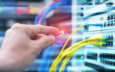Dijital iletişim ve internet için fiber optik merkezi olan ağ sunucu odasında çalışan adam