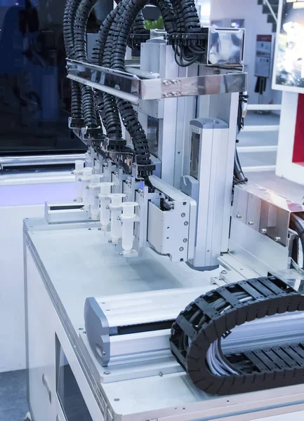 공장에서 접착제 주사기를 들고 있는 로봇 — 스톡 사진