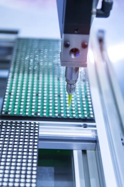 Robot tutkal şırıngasını fabrikada tutuyor.