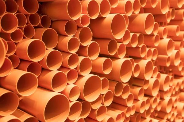 Orange PVC pipes stacked in construction site — Stock Photo, Image