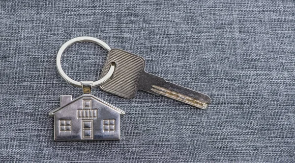Řetězec klíče s symbolem domu a klíčem, koncepce nemovitostí — Stock fotografie