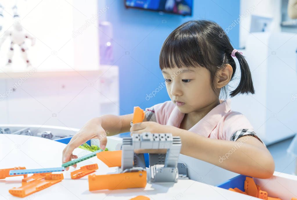 asian girl child having fun playing with colorful plastic blocks