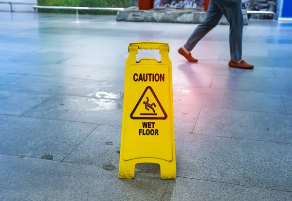 Yellow Caution wet floor sign on wet floor — Stock Photo, Image