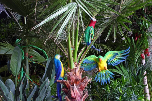 Papoušci v Treetops, zahradní dekorace — Stock fotografie