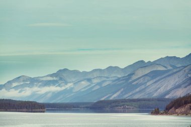 Kanada 'daki dağ gölünün sakin sularındaki kayaların yansımasıyla sakin bir manzara..