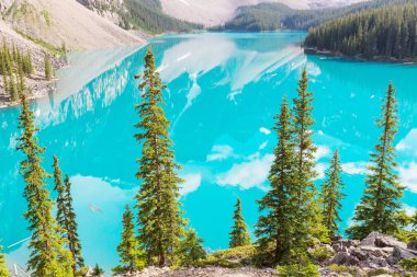 Moraine Gölü 'nün turkuaz suları. Kanada' nın Banff Ulusal Parkı 'nda karla kaplı tepeleri var.