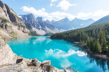 Moraine Gölü 'nün turkuaz suları. Kanada' nın Banff Ulusal Parkı 'nda karla kaplı tepeleri var.