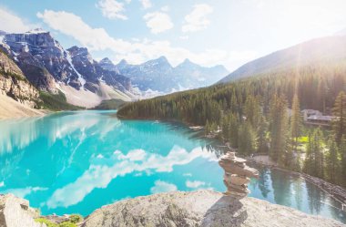 Moraine Gölü 'nün turkuaz suları. Kanada' nın Banff Ulusal Parkı 'nda karla kaplı tepeleri var.