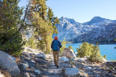 Sierra Nevada dağlarında yürüyen yürüyüş ekipmanlı bir adam, Kaliforniya, ABD