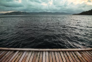 Ahşap iskele, deniz dalgaları ve bir fırtına gökyüzü. Arka plan seyahat. Manzara kavramı.