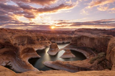 Alışılmadık doğal bir geçmiş. ABD, Utah, Powell Gölü 'ndeki yansıma kanyonu. Güzel gün batımı noktasında dinlenen ilham verici sahne adamı..