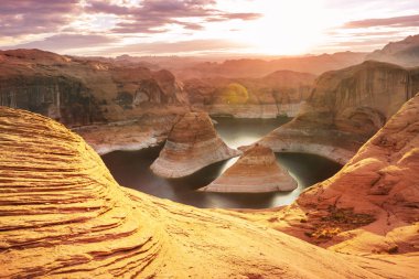 Alışılmadık doğal bir geçmiş. ABD, Utah, Powell Gölü 'ndeki yansıma kanyonu. Güzel gün batımı noktasında dinlenen ilham verici sahne adamı..