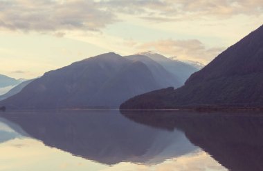Kanada 'daki dağ gölünün sakin sularındaki kayaların yansımasıyla sakin bir manzara..