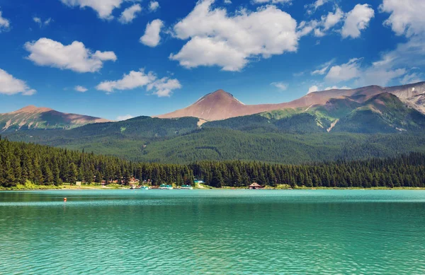 Serene scene by the mountain lake in Canada with reflection of the rocks in the calm water.