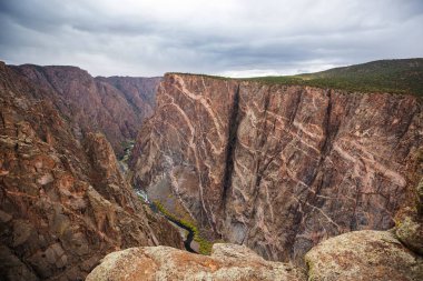 Tourist on the granite cliffs of the Black Canyon of the Gunnison, Colorado, USA clipart