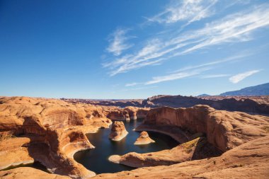 Alışılmadık doğal bir geçmiş. ABD, Utah, Powell Gölü 'ndeki yansıma kanyonu. Güzel gün batımı noktasında dinlenen ilham verici sahne adamı..