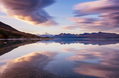 Yeni Zelanda 'daki inanılmaz doğal manzaralar. Gün batımında dağlar göl.