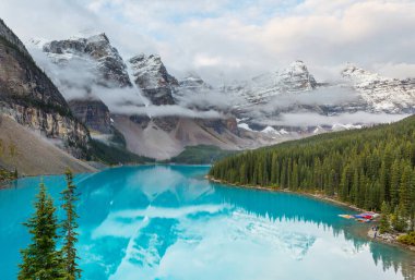 Moraine Gölü 'nün turkuaz suları. Kanada' nın Banff Ulusal Parkı 'nda karla kaplı tepeleri var.
