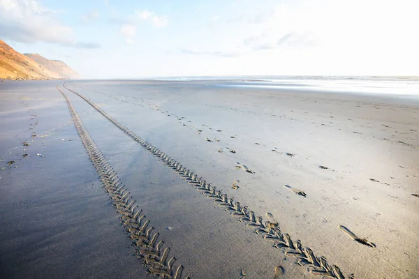 Ślady Opon Samochodu Terenowego Piaszczystej Plaży Oceanem Błękitnym Niebem Wybrzeże — Zdjęcie stockowe