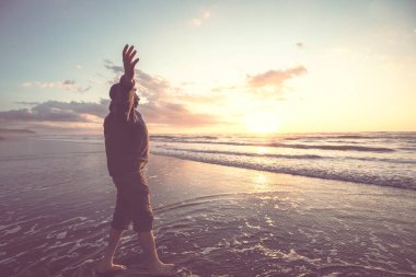 Mutlu adam gün batımında okyanus sahilinde