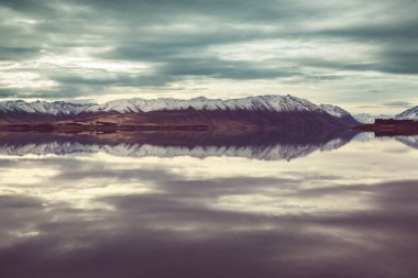 Yeni Zelanda 'daki inanılmaz doğal manzaralar. Gün batımında dağlar göl.