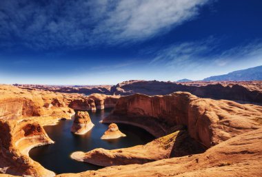 Alışılmadık doğal bir geçmiş. ABD, Utah, Powell Gölü 'ndeki yansıma kanyonu. Güzel gün batımı noktasında dinlenen ilham verici sahne adamı..