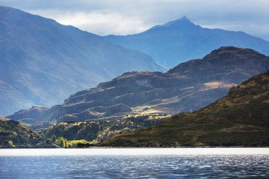 Yeni Zelanda 'daki inanılmaz doğal manzaralar. Gün batımında dağlar göl.