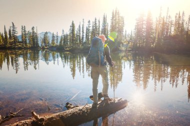 Güzel dağların gölünde dinlenen adam.