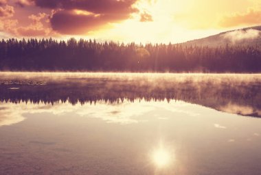 Puslu dağ gölü, sabahın erken saatlerinde dağlarda..