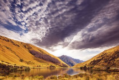 Yeni Zelanda 'daki inanılmaz doğal manzaralar. Gün batımında dağlar göl.