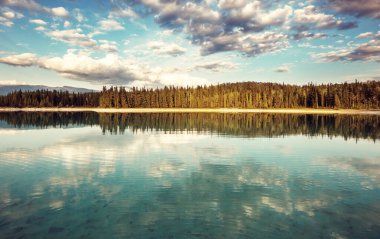 Kanada 'daki dağ gölünün sakin sularındaki kayaların yansımasıyla sakin bir manzara..